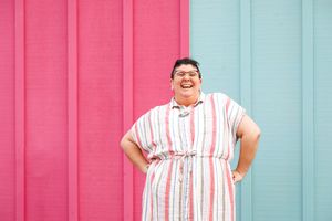 Marina Martinez-Bateman laughing in front of a teal and pink wall